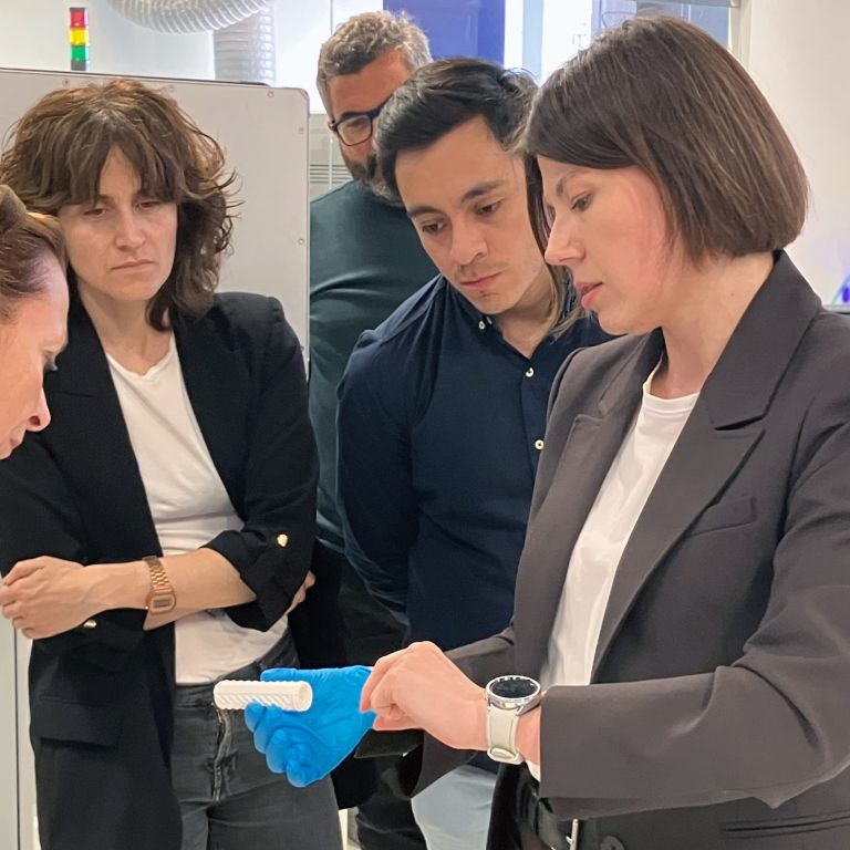 Researchers from the project inspect the 3D-printed membranes during the lab tour.